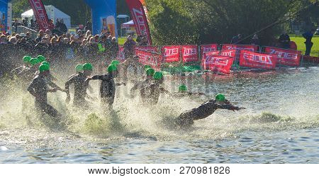 Grafham, Cambridgeshire, England - May 21, 2017:  Triathlon Swimmers Entering Open Water Swim Stage.
