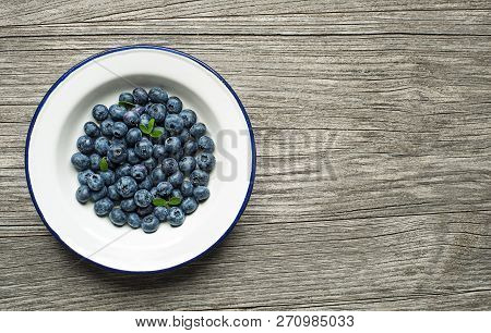 Fresh Blueberries In A Bowl On Wooden Background