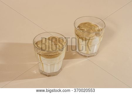 Dalgon Coffee In A Transparent Glass With Milk On A Pastel Background .