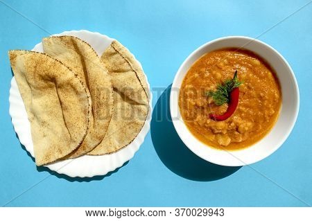 Famous Traditional Arabic Cuisine - Peeled Fava Beans With Chilli In White Bowl And Pita Bread On Bl