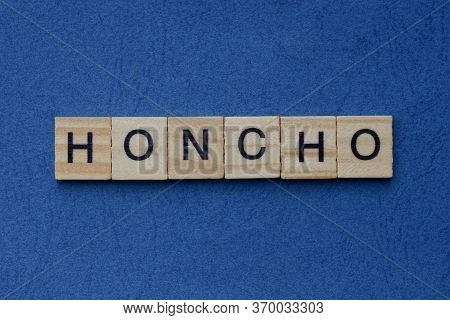 Text On Gray Word Honcho In Small Wooden Letters With Black Font On A Blue Background