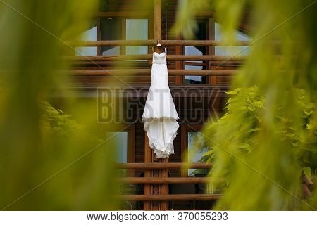 Wedding Dress Is Hanging On A Wooden Hotel, The Beginning Of A Wedding Day