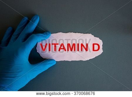 Hand In Blue Glove With White Small Paper. Concept Word Vitamin D.
