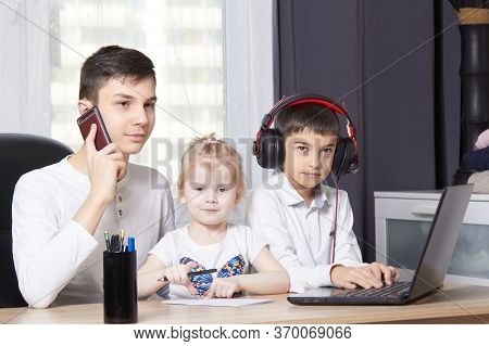 Teenager Talks On The Phone And Writes Down A Task And Children Interfere With Learning