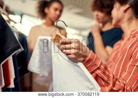 Cropped Shot Of People Looking At Already Made Items, While Discussing Logo And Design Of T-shirt. Y