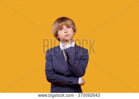 The Blond Boy Thought About The Important And Looks Up. A Finger At The Mouth.
