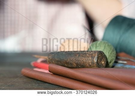 Old Awl And Lether Material With Sewing String On A Tailor Table Close Up.