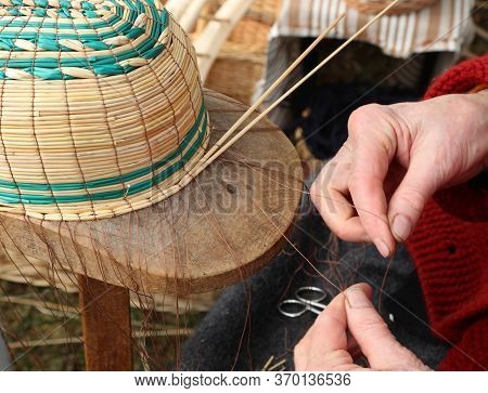 Gnarled Hands Of An Old Craftswoman While Creating A Wicker Basket