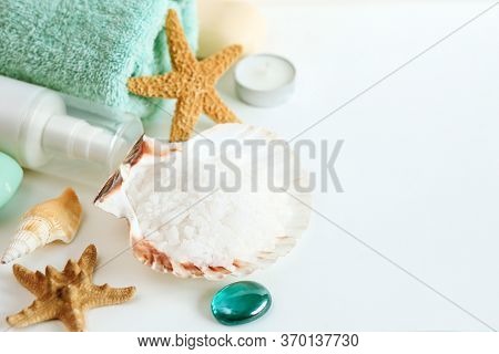 Spa Cosmetics And Towel With Sea Stars And Salt In The Scallop Shell On A White Background On Top
