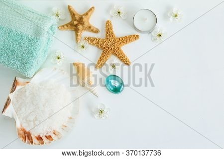 Spa Cosmetics And Towel With Sea Stars And Salt In The Scallop Shell On A White Background On Top