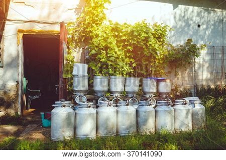 Vintage Milk Cans Standing Oustside The Barn In Rural Countryside Farm