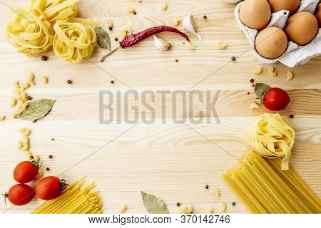 Cooking Food Background With Free Space For Text. Composition With Pasta, Tomato, Eggs, Garlic, Bay 