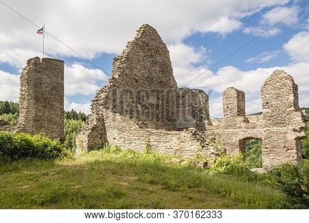 The Ruins Of A Medieval Castle, Illuminated By The Sun On A Slightly Cloudy Summer Day.