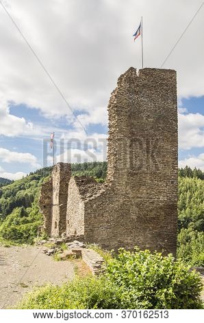 The Ruin Of The Tower Of A Medieval Castle, Illuminated By The Sun On A Slightly Cloudy Summer Day.