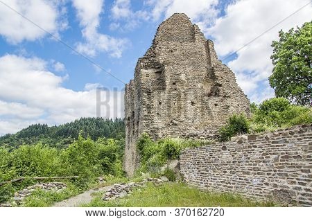 The Ruin Of The Main House Of A Medieval Castle, Illuminated By The Sun On A Slightly Cloudy Summer 