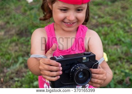 Little Girl Shooting Blog On Retro Photo Camera сlose Up.