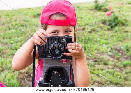 Little Girl Shooting Blog On Retro Photo Camera сlose Up.