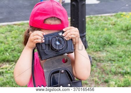 Little Girl Shooting Blog On Retro Photo Camera сlose Up.
