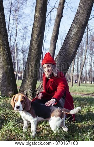 Pretty Young Girl In Redd Coat Playing With Dog Outside In Green Park, Lifestyle People Concept