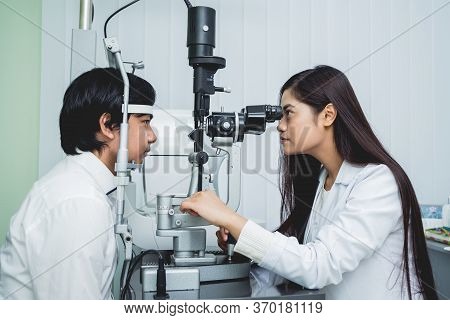 Consultation With An Ophthalmologist. Young Asian Man And Woman Doctor