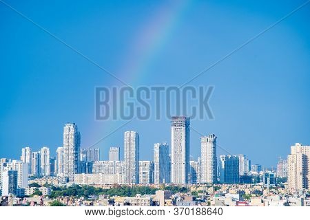 Aerial Cityscape Shot Of Buildings In Gurgaon Delhi Noida With A Rainbow Behind Them On A Monsoon Da