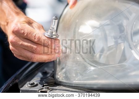 Young Man Hands Changing Car Bulb Or Flashbulb Of The Front Headlight Or Headlamp, Repairing Car Con
