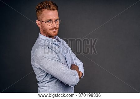 Serious-looking Confident European Man With Redbeard In Trendy Glasses And Denim Shirt, Holding Hand