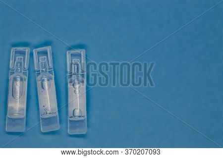 Plastic Capsules With Medical Vaccine On A Blue Background Close-up