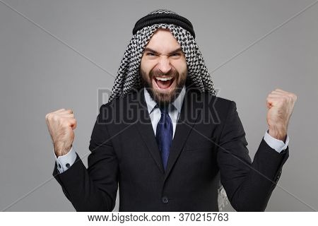 Happy Young Bearded Arabian Muslim Businessman In Keffiyeh Kafiya Ring Igal Agal Classic Black Suit 