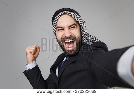 Close Up Of Arabian Muslim Businessman In Keffiyeh Kafiya Ring Igal Agal Suit Isolated On Gray Backg