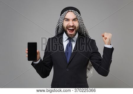 Happy Arabian Muslim Businessman In Keffiyeh Kafiya Ring Igal Agal Isolated On Gray Background. Achi