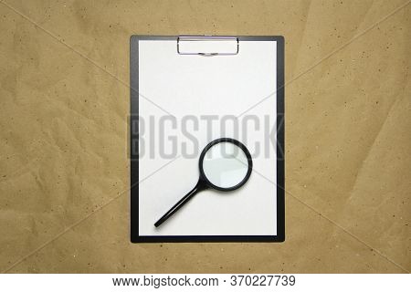 A Tablet With A White Sheet Of A4 Format With Magnifier On A Beige Craft Paper. Concept Of Analysis,