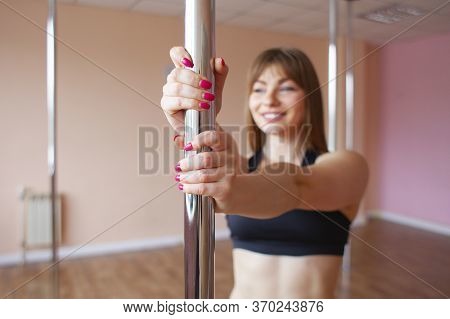 Young Sports Girl In Pole Dance Training, Novice Gymnast Stands In The Hall Smiling And Holds A Pylo