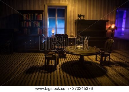 A Realistic Dollhouse Living Room With Furniture And Window At Night. Artwork Table Decoration With