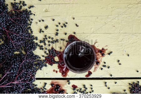 Fresh Ripe Violet Black Elderberries, Squeezed And Pressed And Elderberry Juice, On Rustic Grey Yell