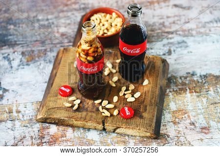Kharkiv / Ukraine - June 6 2020: Selective Focus. Macro. Coca Cola Bottle With Peanuts. Peanuts With