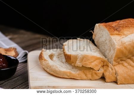 Close Up Fresh Homemade Loafs Bread And Sliced Bread On Cutting Board With Jam Strawberry On Wooden 