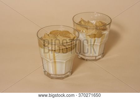 Dalgon Coffee In A Transparent Glass With Milk On A Pastel Background .