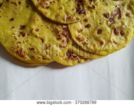 Closeup Of Yellow Color Traditional Dal Obbattu Or Holige In A Plate Isolated On White Background