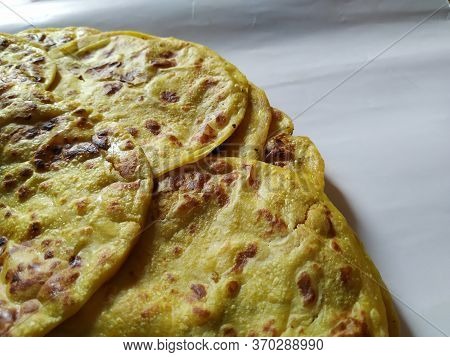 Closeup Of Yellow Color Traditional Dal Obbattu Or Holige In A Plate Isolated On White Background