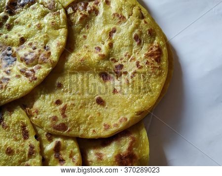 Closeup Of Yellow Color Traditional Dal Obbattu Or Holige In A Plate Isolated On White Background
