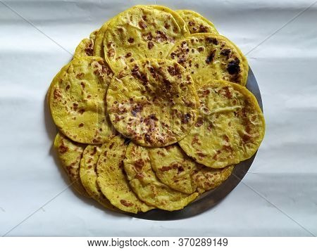 Closeup Of Yellow Color Traditional Dal Obbattu Or Holige In A Plate Isolated On White Background