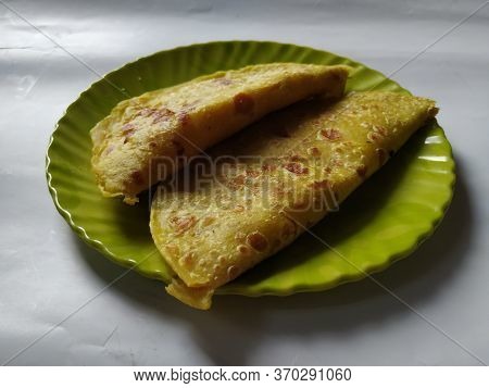 Group Of Yellow Color Traditional Dal Obbattu Or Holige In A Plate Isolated On White Background