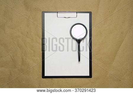 A Tablet With A White Sheet Of A4 Format With Magnifier On A Beige Craft Paper. Concept Of Analysis,