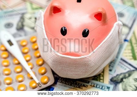 Piggy Bank In A Mask On A Background Of American Currency.the Concept Of Coronavrius Epidemic