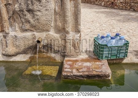 Box Full Of Bottles Ready To Be Filled At Palomas Pillar Fountain, Hornachos, Spain. Imperial Coat O