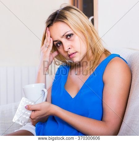 Blonde Spanish Female With Antibiotic And Glass Of Water Indoors