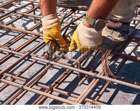 Hands Of Worker Tying Reinforcement Rebars With Haywire
