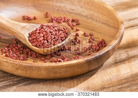 Organic Achiote Seeds - Bixa Orellana. Wood Background