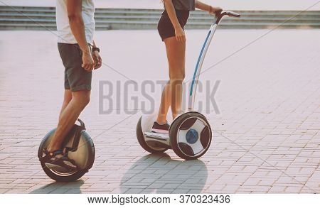 Young Couple Driving On Monowheel In The Park